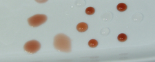 Wasser und Rotwein auf einer partiell mit WAYTONA® Keramikversiegelung versiegelten (rechte Seite) Keramischen Ablageschale. Deutlich zu erkennen der Abstoßeffekt der nanoversiegelten Oberfläche.